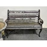 A two seater garden bench, of typical cast metal and wooden slat form. the arms with lion mask