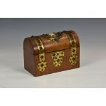 An antique walnut stationary box with domed lid, having ornate studded brass mounts and central