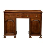 An early 20th century oak desk, the moulded top over a pair of drawers with original drop handles,
