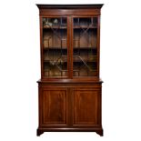 A good Edwardian mahogany and satinwood glazed cupboard bookcase, the dentil cornice over a