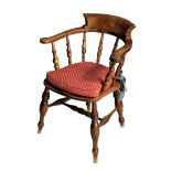 A beech and oak Victorian captain's chair, the curved, crested back with turned spindle supports,