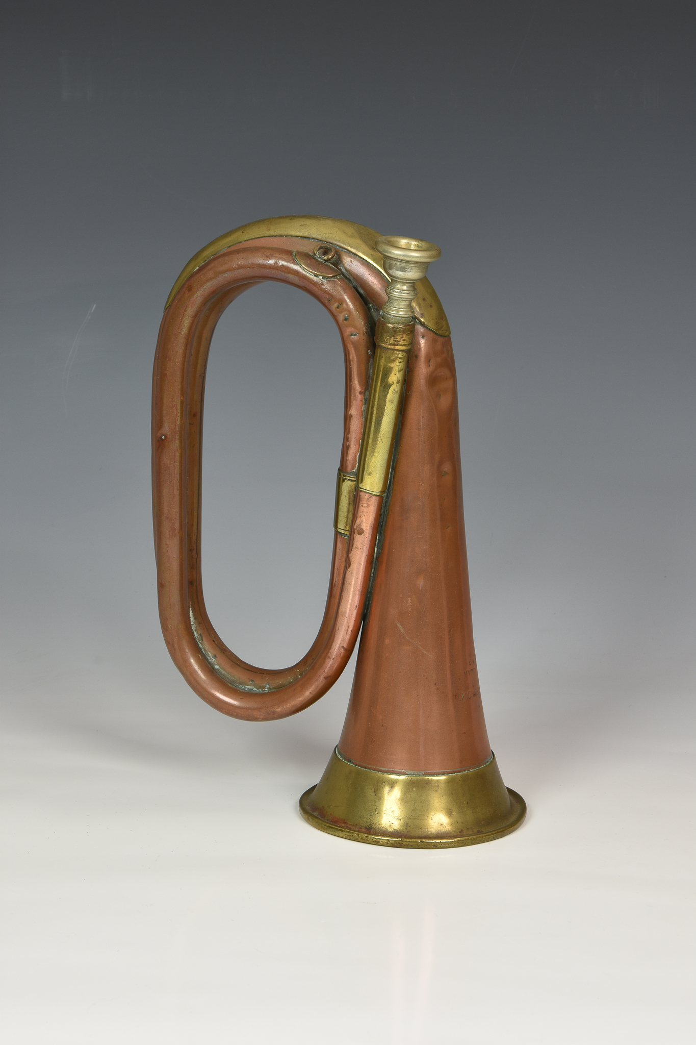 A 1916 WWI military issue USA cavalry copper & brass bugle by J W York & Sons, of typical form,