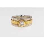 An 18ct white and yellow hammered gold diamond solitaire ring, featuring a wide, white gold band