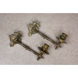 A pair of ornate Victorian bronze pivoted candle wall sconces, with shaped and decorated back