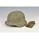 A WWII German M40 camouflaged steel helmet and liner with helmet cover, rolled rim and pressed vent,