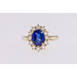 An 18ct gold, Ceylon sapphire and diamond cluster ring, the central Ceylon sapphire weighing