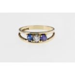 A 10ct gold and paste ring, featuring circular white, blue and purple paste on a bifurcated shank,