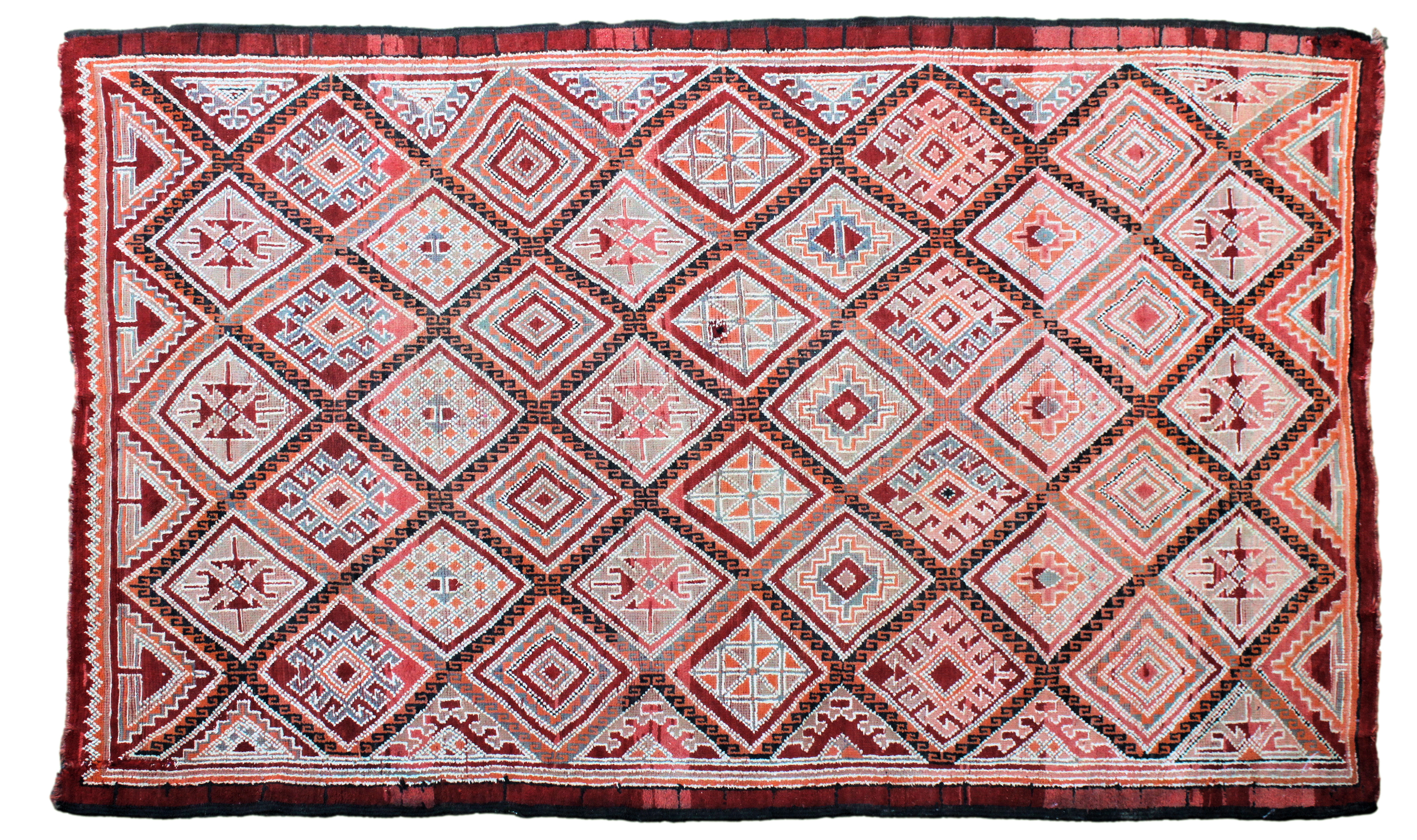 A large Kilim rug, 20th century, with all over diamond medallion decoration in muted reds, orange