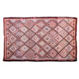 A large Kilim rug, 20th century, with all over diamond medallion decoration in muted reds, orange