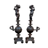 A pair of 18th century style cast iron figural fire andirons, each with a putti atop a cup and