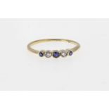 A vintage 18ct gold, sapphire and diamond five stone ring, 1920s-30s, rub over set with three