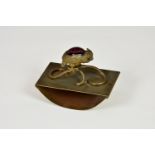 A novelty brass ink blotter, fashioned with an owl finial, with amethyst coloured glass back and