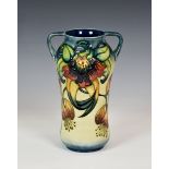 A modern Moorcroft Pottery twin handled vase in the 'Anna Lily' pattern, of slightly waisted form,