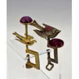 Two Hummingbird sewing clamps, both with rectangular foliate decorated frames below pin cushions,