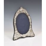 An Edwardian style silver easel back photo frame, John Bull Ltd., London 1987, shaped oval form,