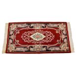 An Eastern Kayam OCM wool rug, 20th century, on red ground and guard border with floral main