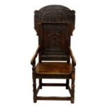 An oak wainscot style chair with Masonic carving, the arched back with solid recessed splat to