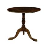 A George III mahogany tripod table, the circular top over a baluster turned column raised to three
