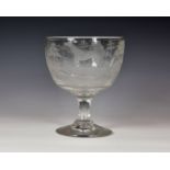 An early 19th century oversized ornamental glass goblet, the large cup bowl wheel engraved with a