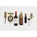 A collection of novelty corkscrews, to include two fashioned as wine bottles, the larger 'CLOS-DE-