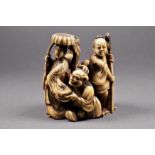 A Japanese carved ivory okimono, 18th / 19th century, depicting two ladies and a man with an axe