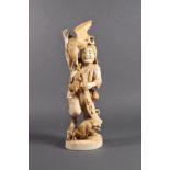 A Japanese carved ivory okimono of a hunter, Meiji period (1868-1912), the hunter holding a