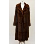 A full length glow mink coat, 1950s-60s, with floral sprigged brown silk lining, two hook
