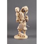 A Japanese carved ivory okimono of a performer, Meiji period (1868-1912), the man with a drum in one