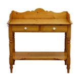 A Victorian pine wash stand, the three quarter shaped gallery, over two drawers on turned legs