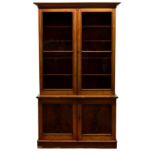 A Victorian mahogany display bookcase, the flared cornice over two glazed doors enclosing adjustable