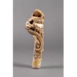 A Japanese carved bone walking cane handle, 19th century, with a toad seated upon a slender pile