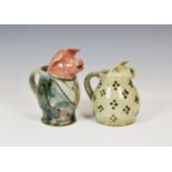 Two novelty Alderney Pottery pig cream jugs, the largest measuring 6 3/8in. (16.2cm.) high. (2)