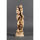 A Japanese carved ivory okimono of a father and child, Meiji period (1868-1912), the man standing on