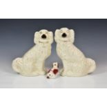 A pair of Victorian white glazed Staffordshire dogs, having gilt highlights, 10 5/8in. (27cm.) high,