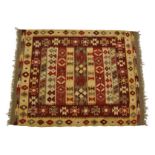 An Afghan kilim rug, in tones of brown, red, grey and ivory with geometric designs and unresolved