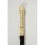 A antique spirally carved ebony walking cane with carved bone pommel and ferrule, 37in. (94cm.)