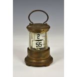 A gilt brass Plato or ticket clock, early 20th century, with two registers of tickets displaying the