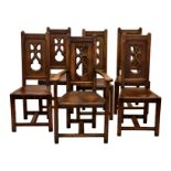 A set of six early 20th century Arts & Crafts Gothic style oak chairs, with pierced splat over
