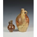 Two 17th century stoneware salt glazed Bellarmine wine jugs / flagons, the first of small