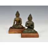 Two bronze seated Indian / Hindu deities or Gods, in meditating poses, raised on wooden