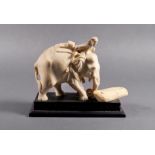 An Indian carved ivory figure of an elephant mahout, 19th century, the mahout astride the neck leans