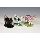 Three 19th century Staffordshire cow creamers, comprising a lustre glazed cow, decorated with