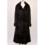 A full length mahogany mink coat by Charisma of Guernsey, with cuffed sleeves, buttoned half-belt,