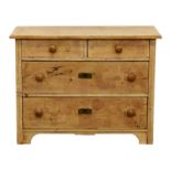 A Continental pine chest of drawers, c.1900, the chamfered top over two short and two long