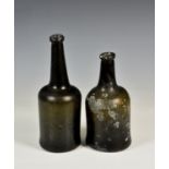 Two 18th century glass wine bottles, the first of squat cylindrical form with deep kick to base,