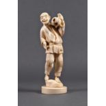 A Japanese carved ivory okimono of a man with a pumpkin, Meiji period (1868-1912), standing on a