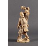 A Japanese carved ivory okimono of a farmer, Meiji period (1868-1912), holding a sickle in one
