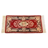 An Eastern Kayam OCM wool rug, 20th century, on red ground and guard borders with floral main border