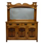 An Arts and Crafts honey oak dresser, c.1910, the mirrored back with shaped top pierced with yin