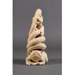 A Japanese carved ivory okimono, Meiji period (1868-1912), carved as a snake coiled on the back of a